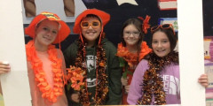 Troy students wear orange clothes and hats while posing for a picture in support of Unity Week