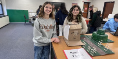 two female Learwood students stand next to their model representation of the Roman Forum
