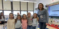 Westview teacher and students stand in classroom wearing similar outfits