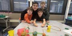 Redwood students smile in front of their roller coaster project made from common household materials