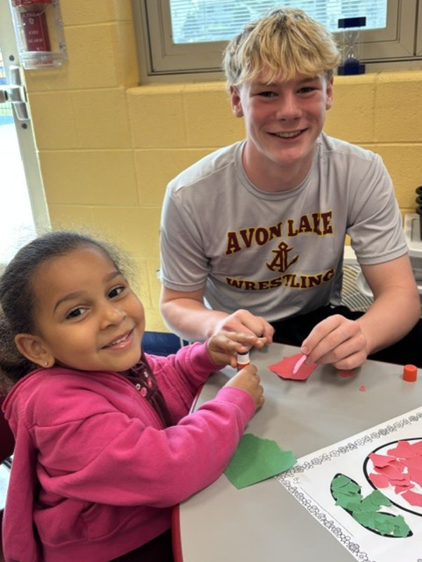 ALHS student sits next to Artemus Ward Elementary student