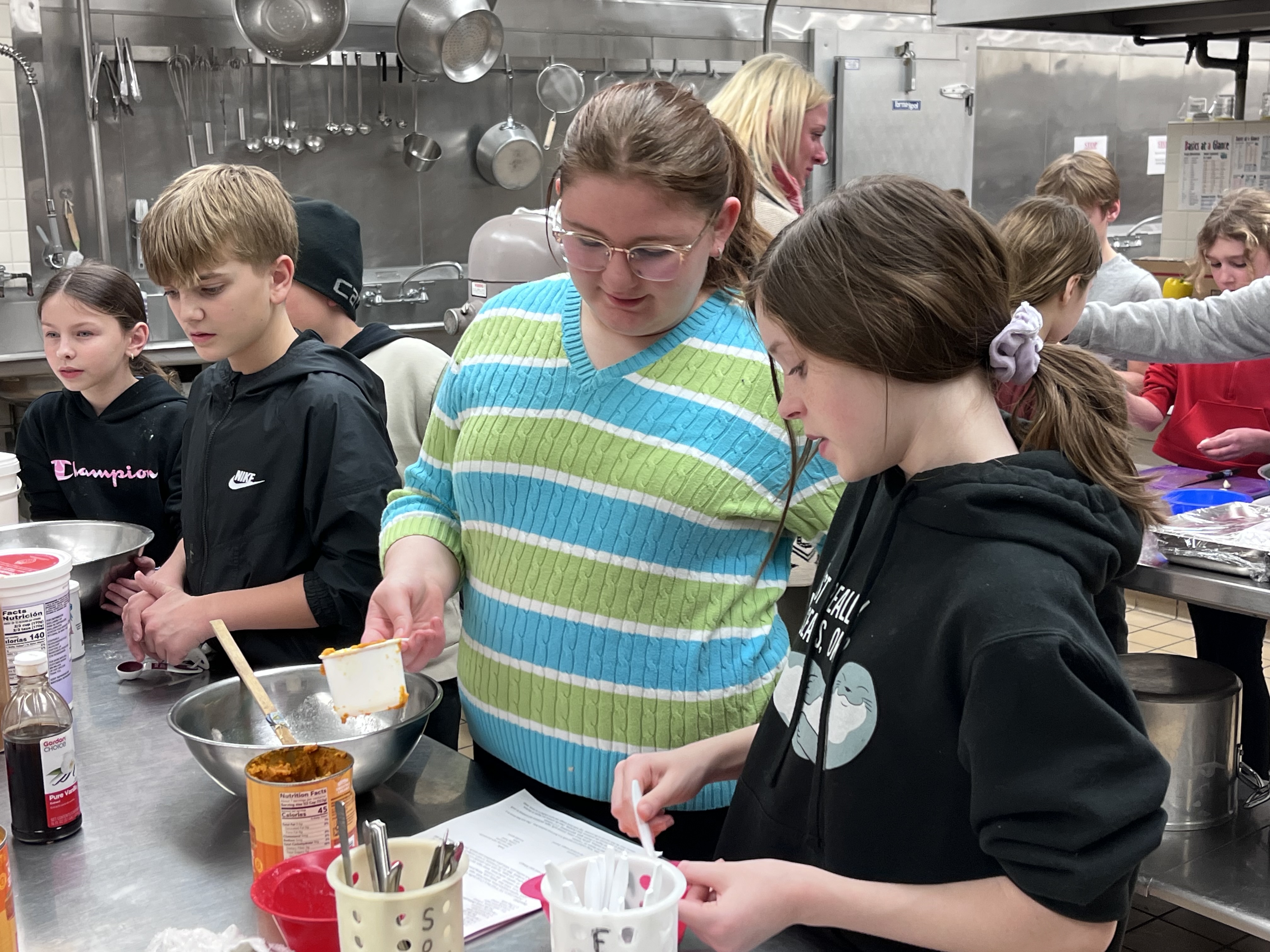 Troy students mix ingredients in bowl