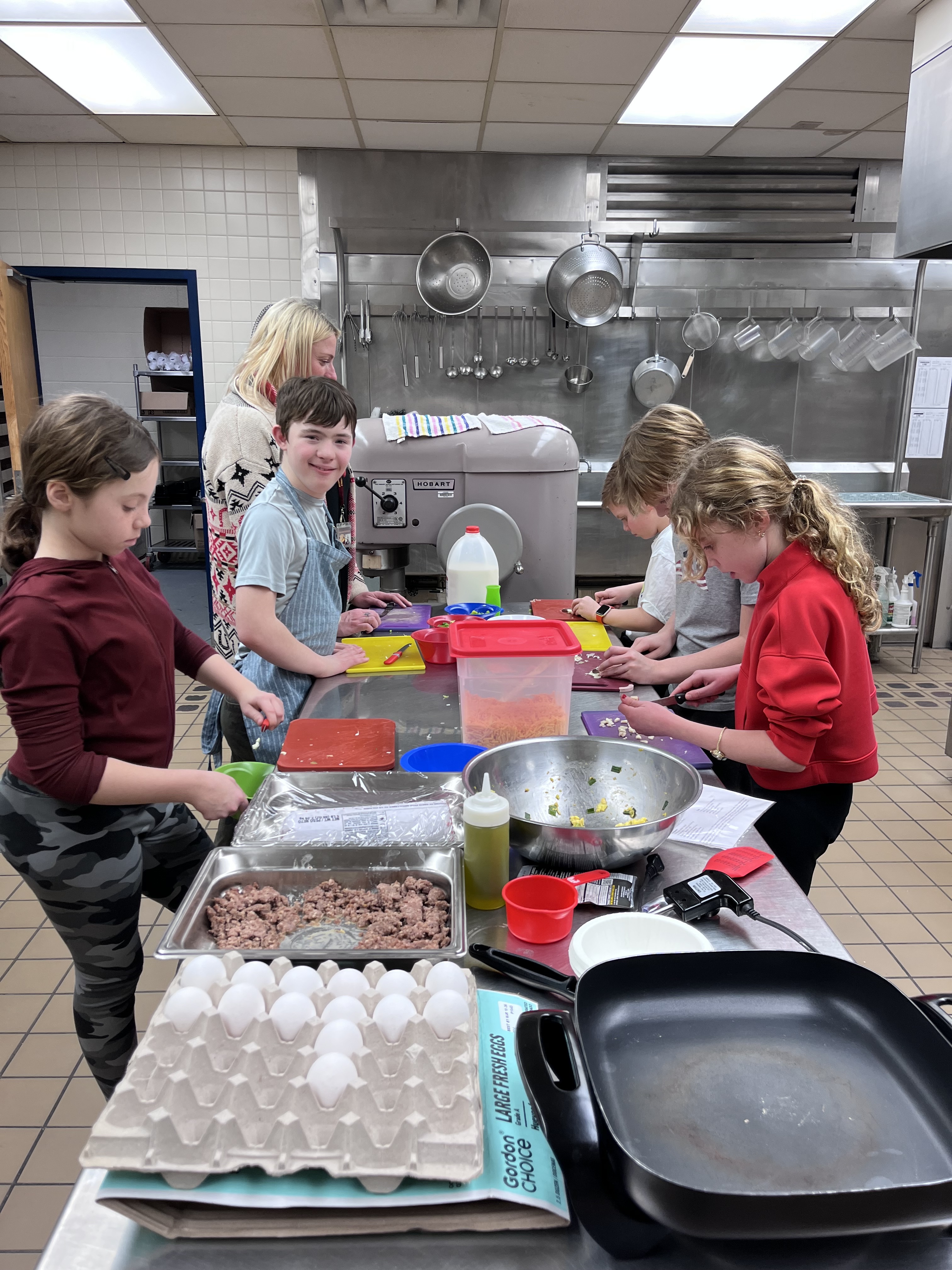Troy students cut up vegetables under supervision of staff