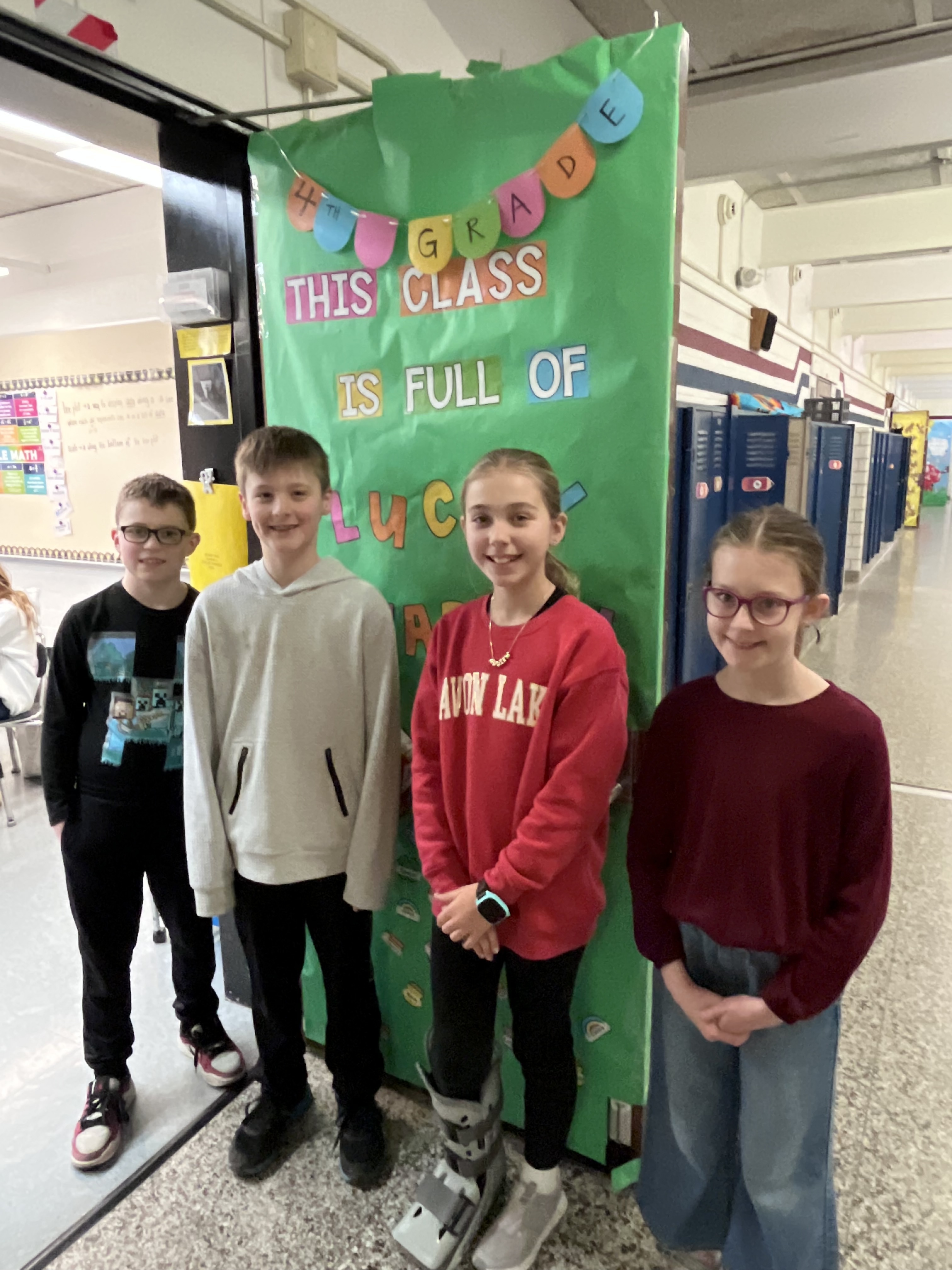 Redwood students stand outside decorated classroom door