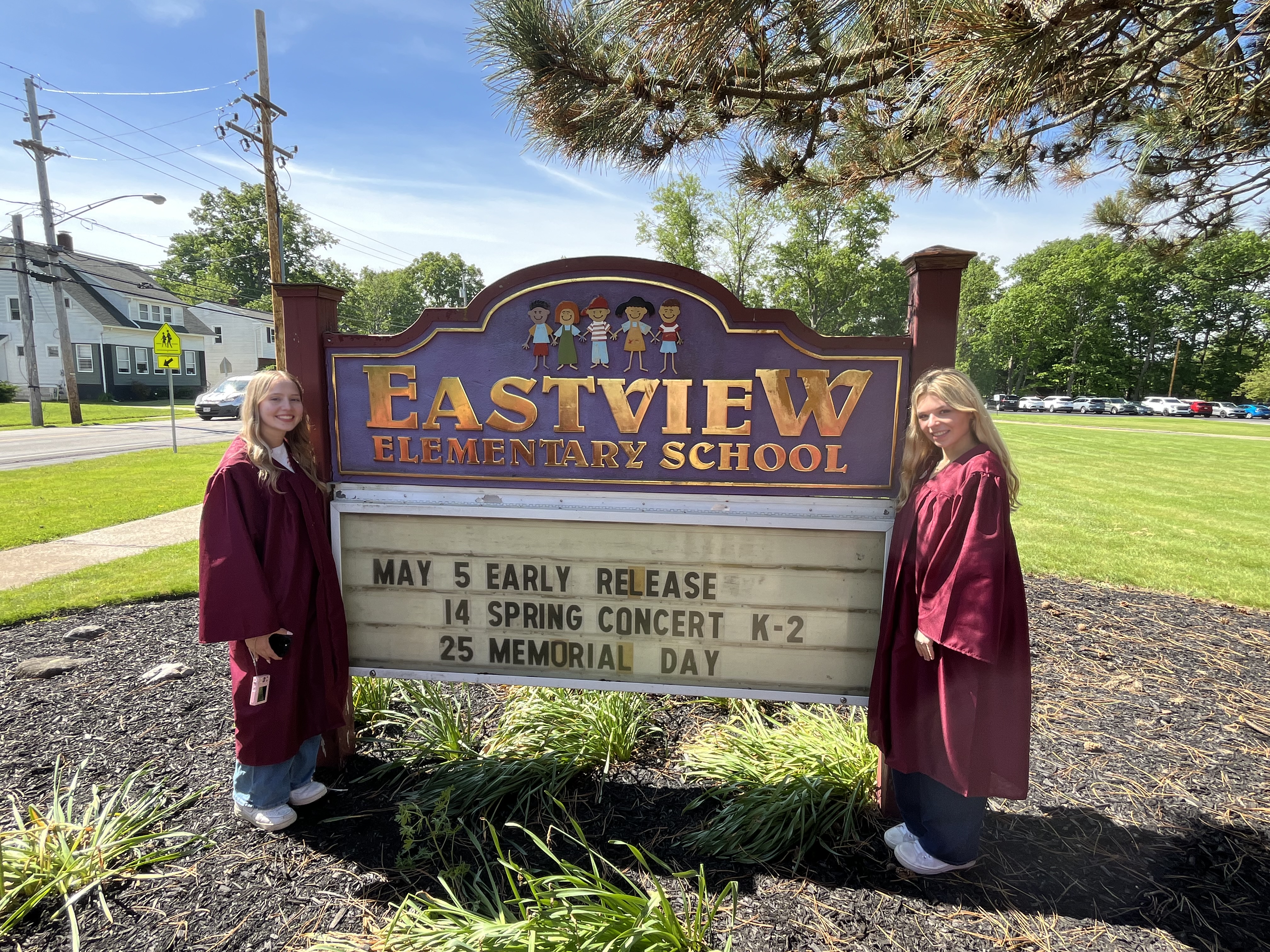 ALHS Class of 2026 members stand next to Eastview Elementary School Sign