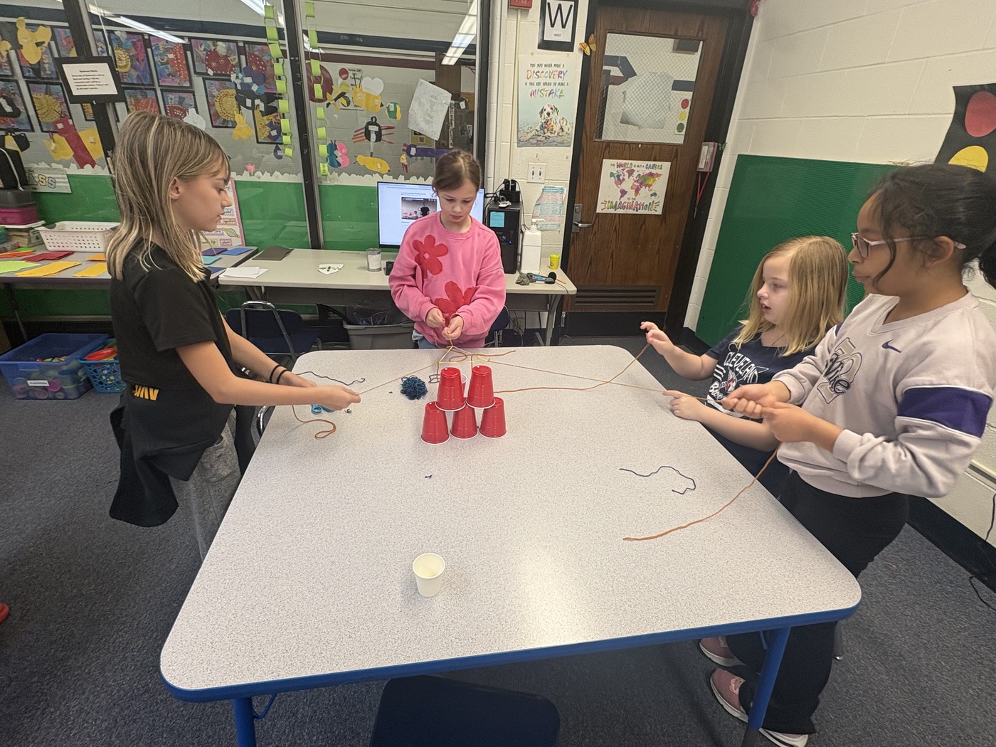 Redwood students work together to build using plastic cups